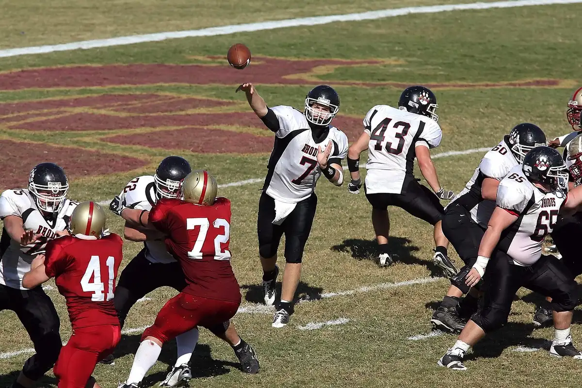 College quarterback in passing motion during a football game