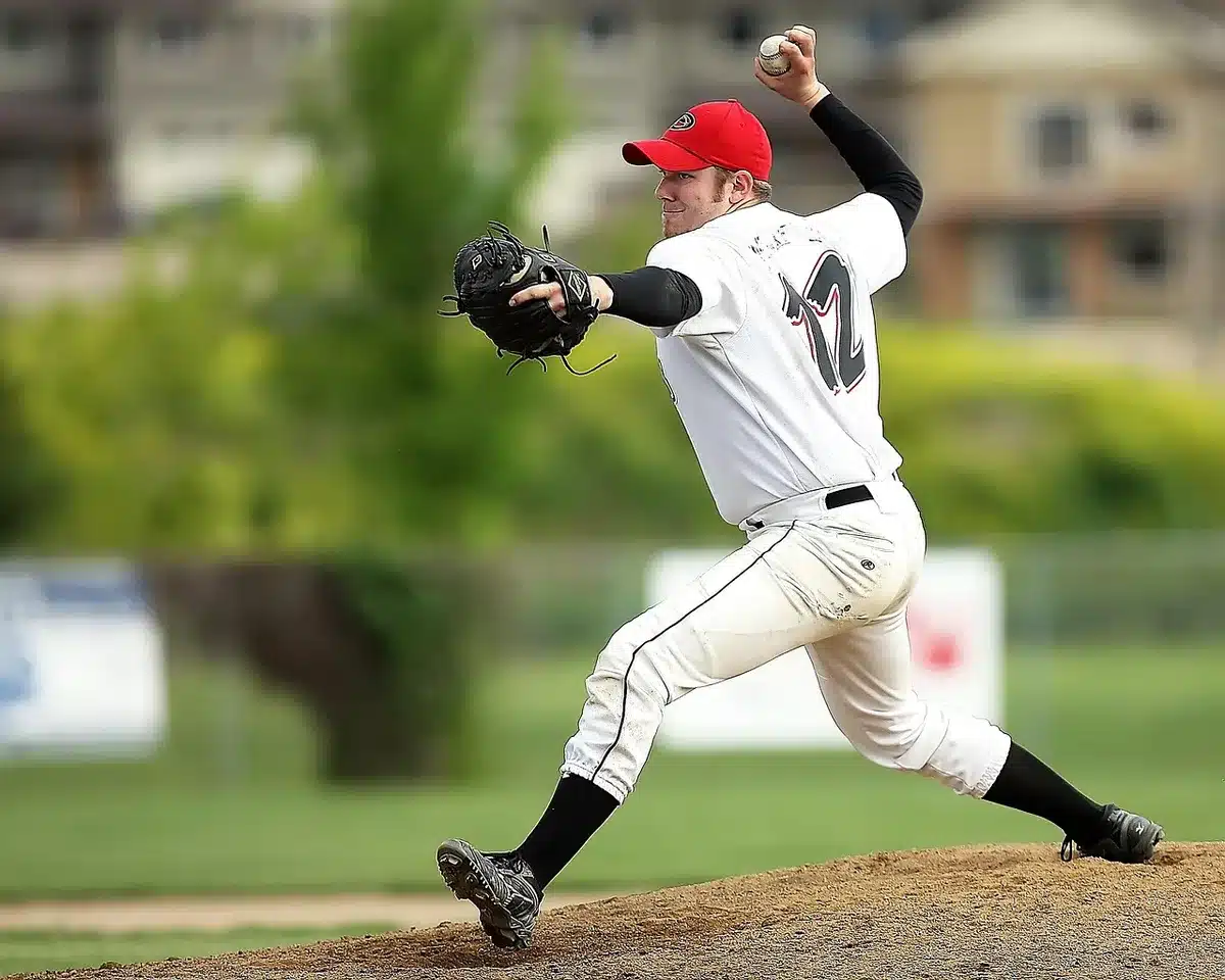 Baseball pitcher in mid-delivery on the mound during a night game