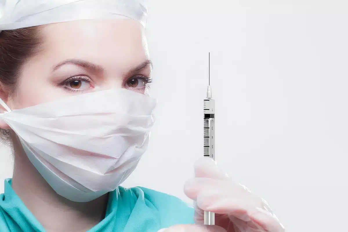 Syringe and medical vial in a modern laboratory environment with soft lighting