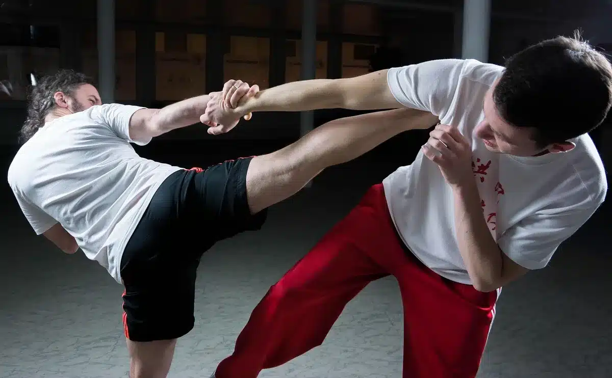 Fighter executing a leg kick in the octagon with power and precision