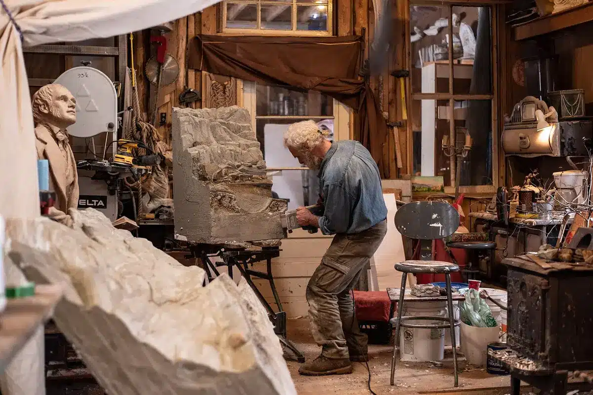 Sculptor and foundry workers working on a large bronze casting