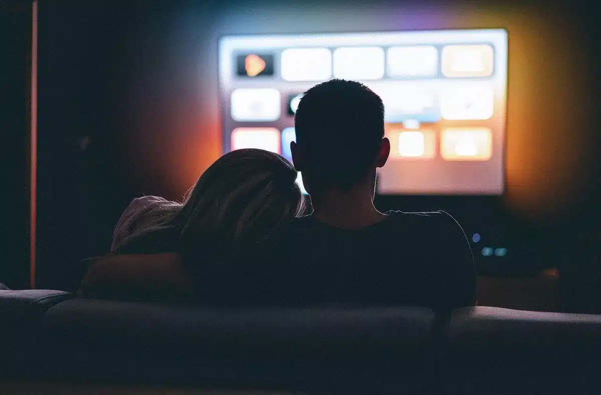 Group of friends under a blanket watching a movie together