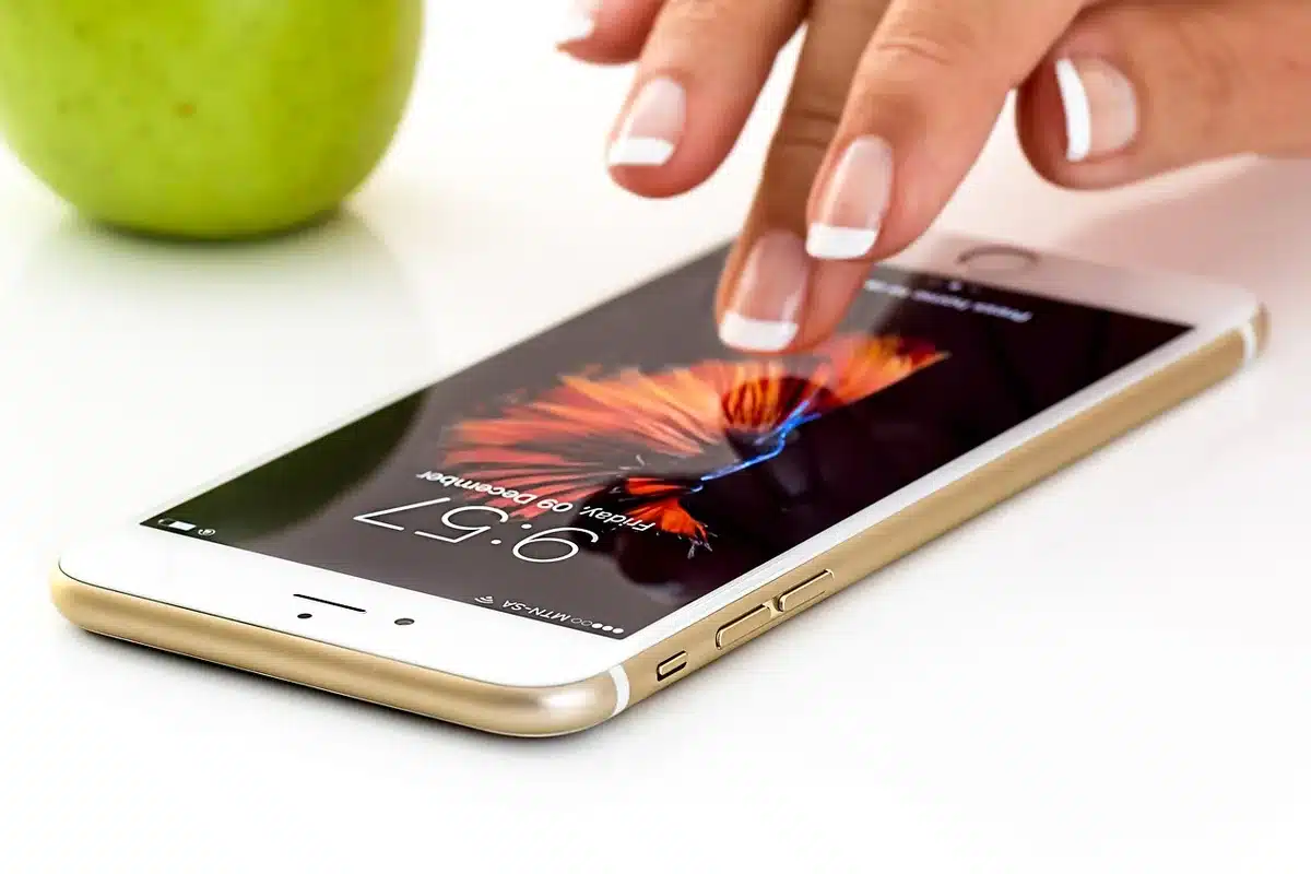 Hand holding a phone displaying an SOS beacon and compass in an emergency app