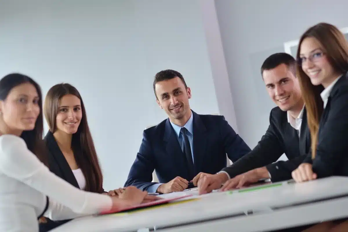 Front office executives around a table reviewing contracts and spreadsheets