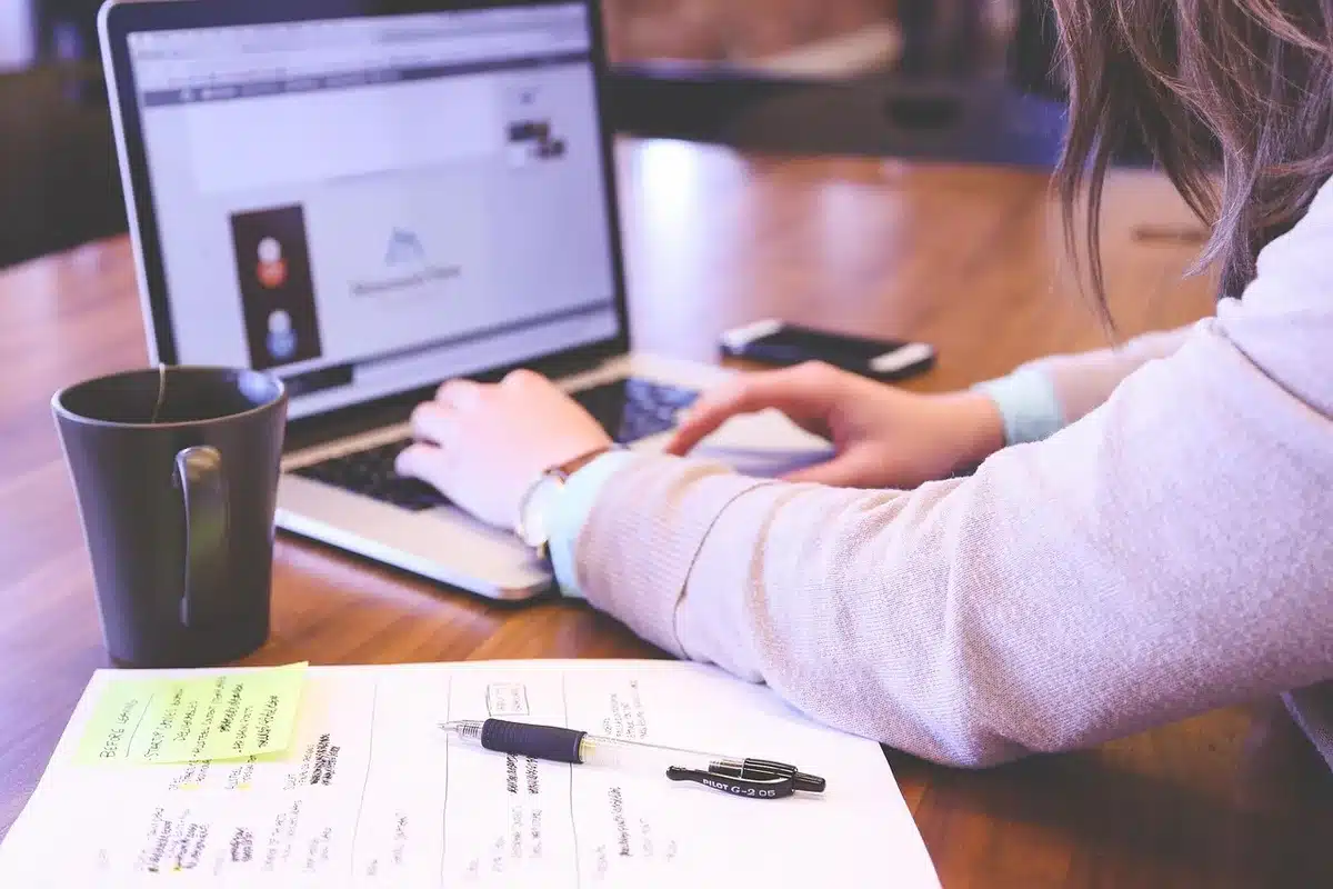 Hands typing on a laptop signing into a supporters site