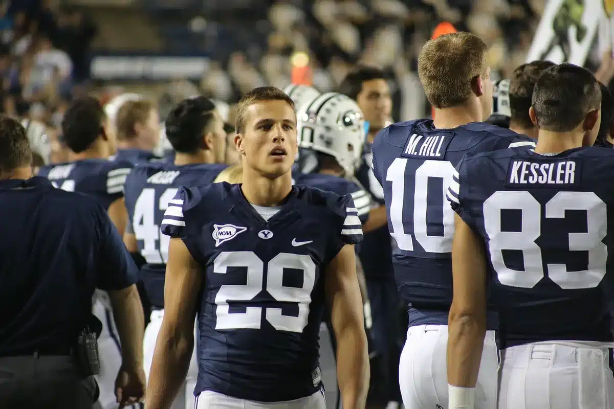 Edge rusher on the sideline holding his ankle after a play