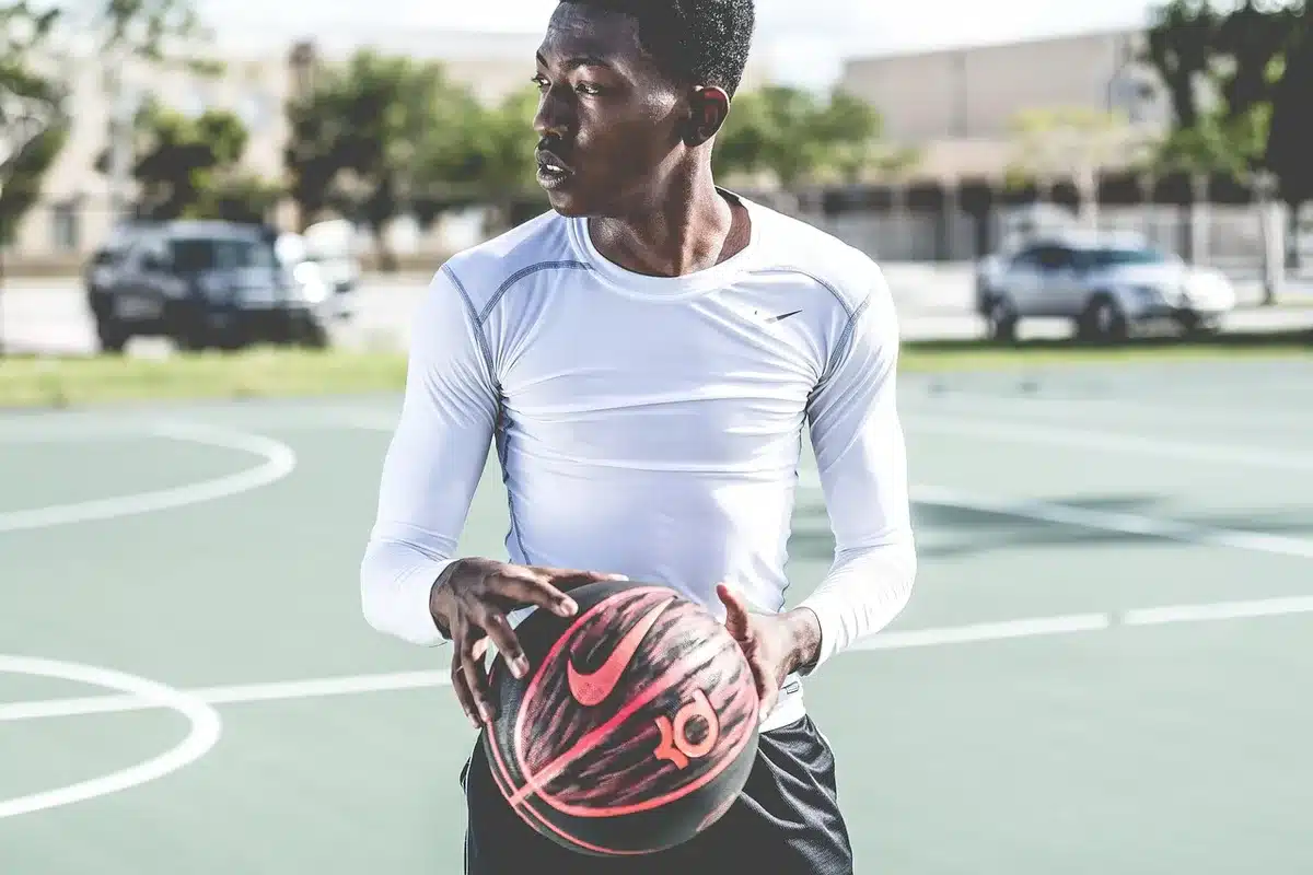 Silhouette of a basketball player on court holding papers