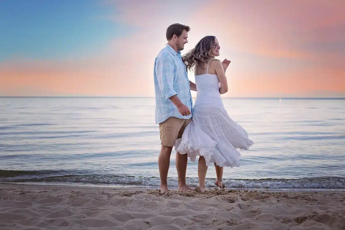 A playful couple outdoors with a frisbee and sunscreen, capturing physical comedy